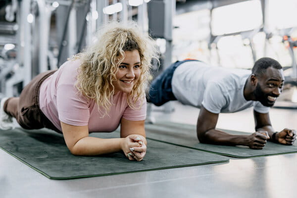 Planking partners having fun at the gym, fitness motivation