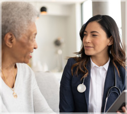 Health care worker talking with older woman