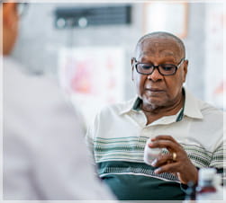 Older man reading medicine bottle