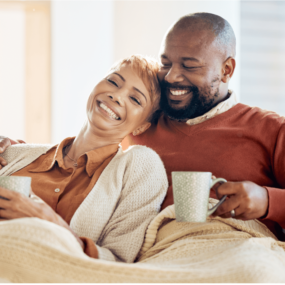 Love, black couple and coffee with blanket, being happy or smile together for bonding, loving and in loung