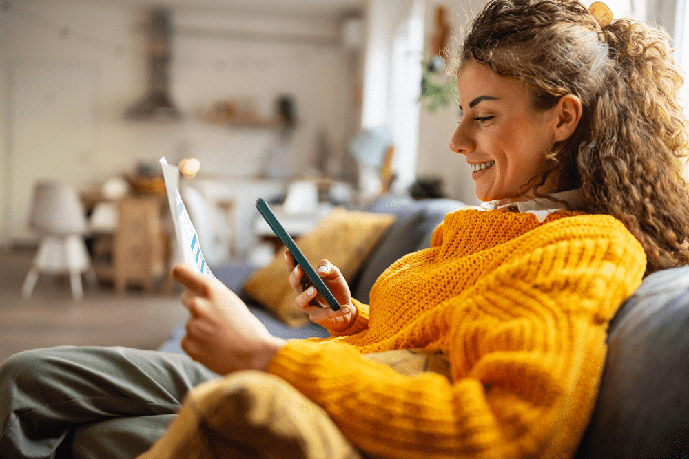 Side-view of an young Caucasian woman using smartphone for scanning the QR code and paying the bill