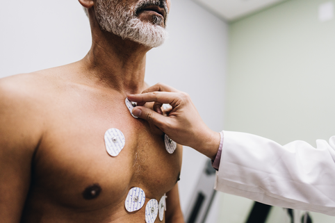 Close-up of human hands putting sensors of electrocardiography on a doctor's office