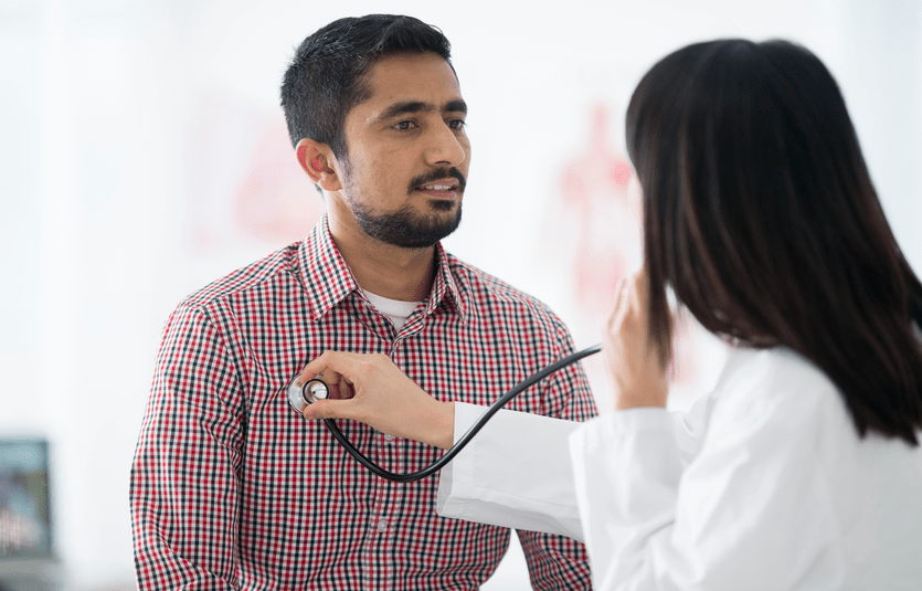 A man is getting an annual check up at the doctors office.