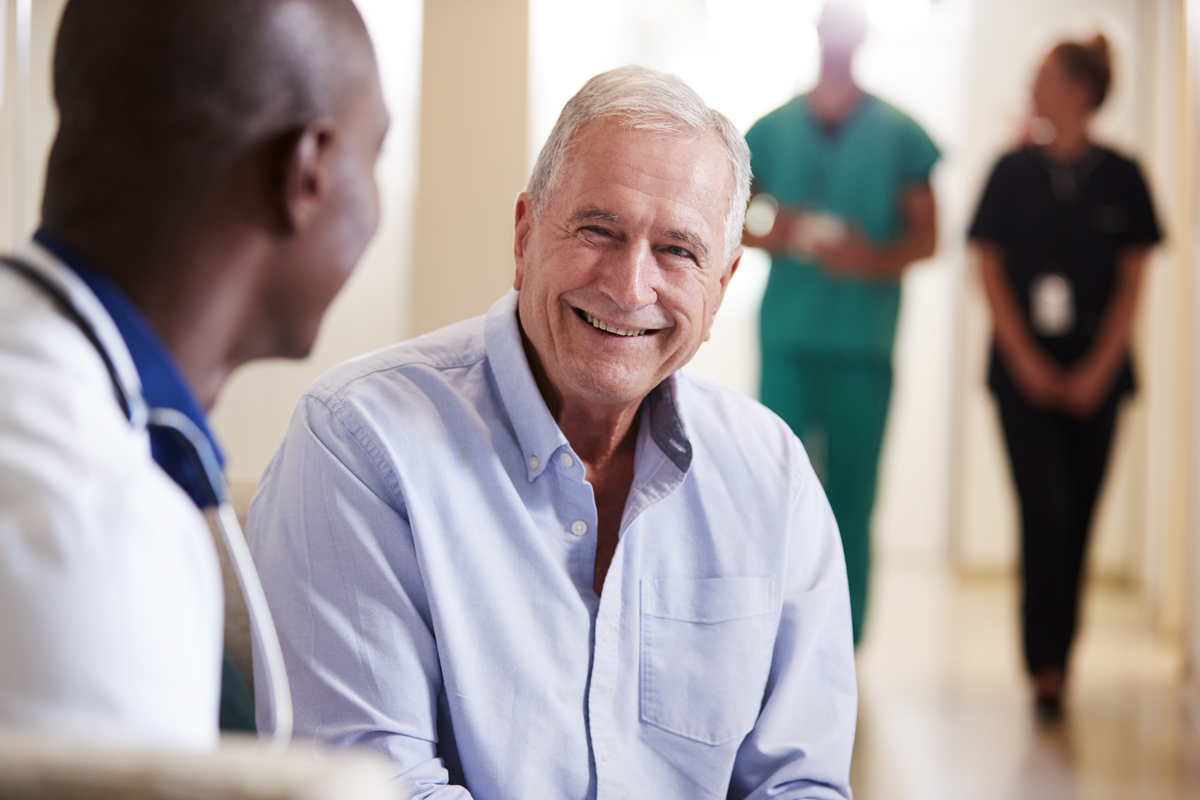 Doctor Welcoming To Senior Male Patient Being Admitted To Hospital