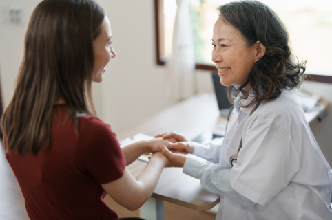 Female doctor holding the hands of a  female patient