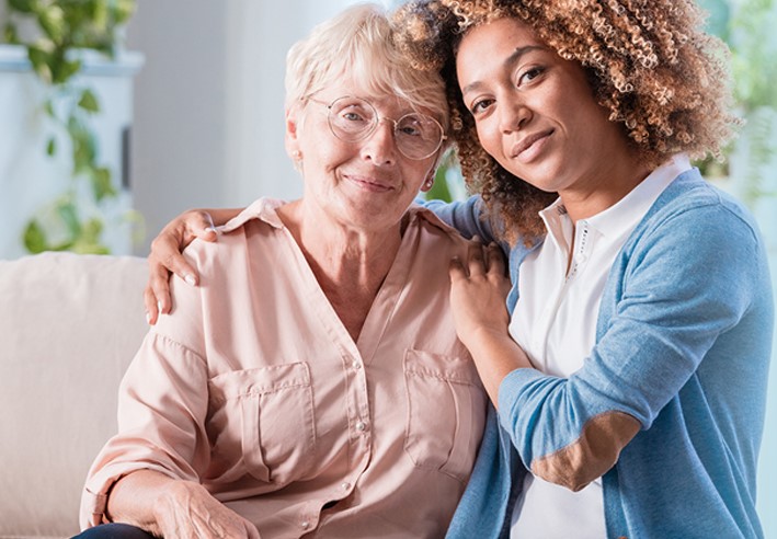 Healthcare with arm around older woman
