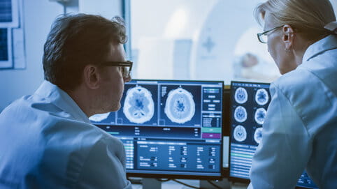In Control Room Doctor and Radiologist Discuss Diagnosis