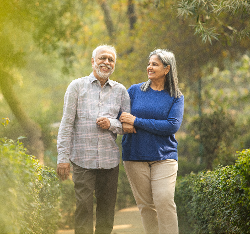 Smiling senior husband and wife walking in garden representing dementia awareness, memory care, and neurological health services at Riverside Health