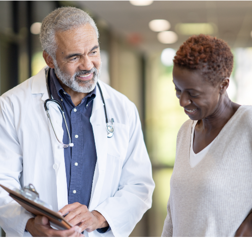 Doctor and Patent Talking in the Hallway representing dementia awareness, memory care support, and neurological health services at Riverside Health.