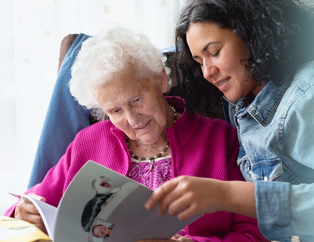 Older woman and younger healthcare worker, reading