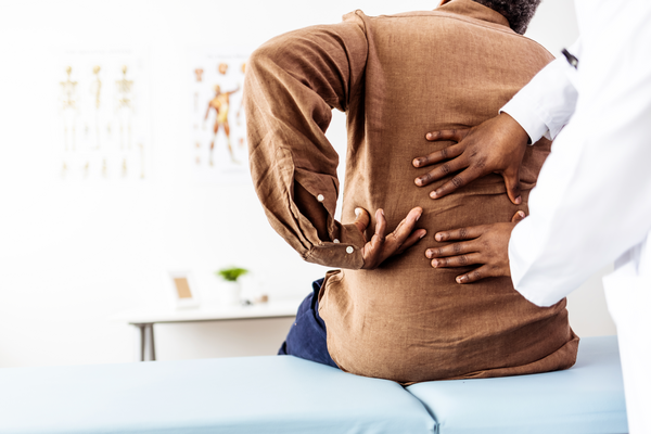 Doctor physiotherapist doing healing treatment on man's bac