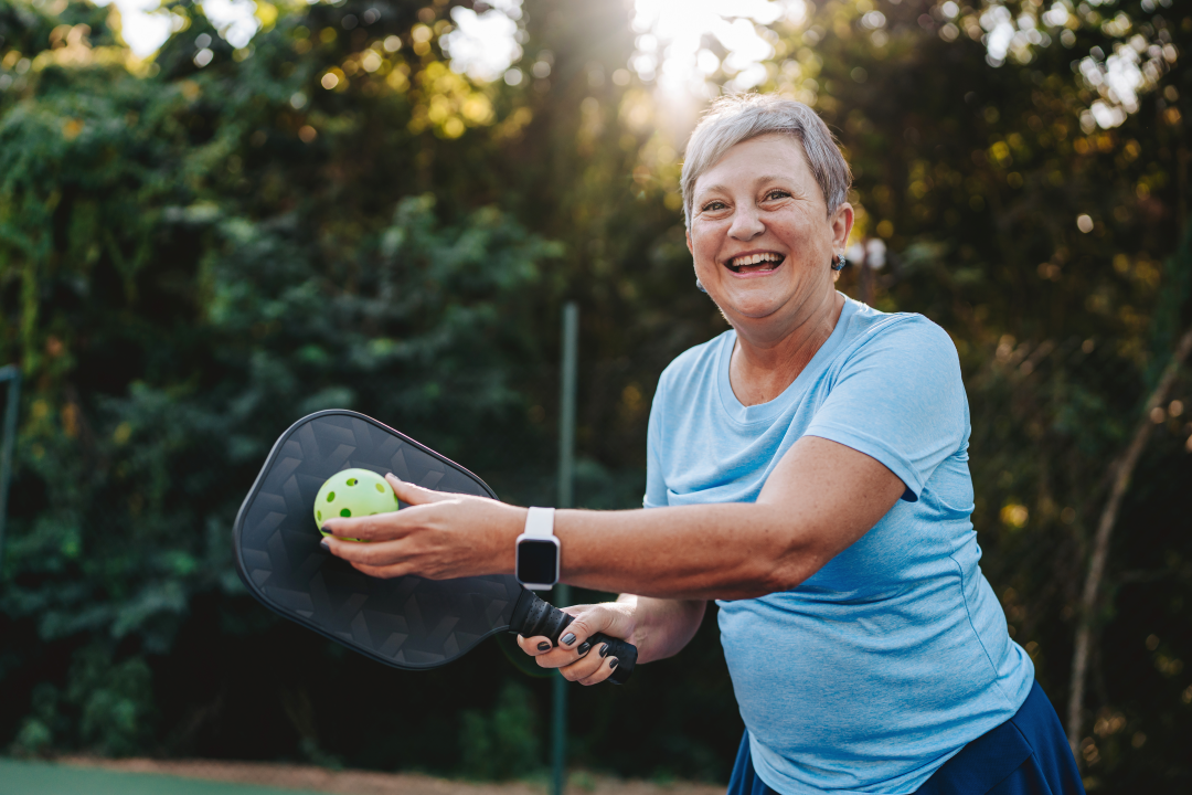 Portrait senior woman playing pickleball smiling