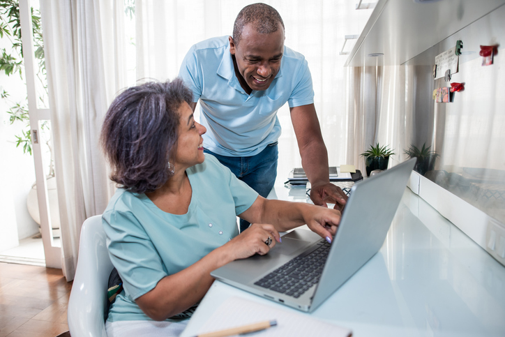middle age couple typing on computer