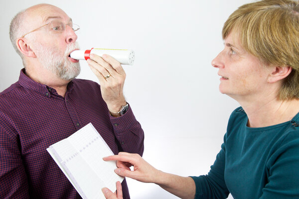 Doctor reviews patient's lung capacity with a peak flow meter