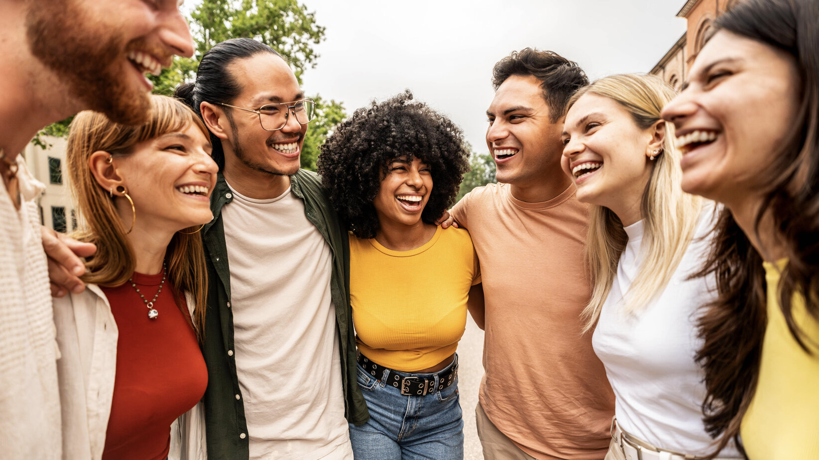 Multicultural young people hugging together
