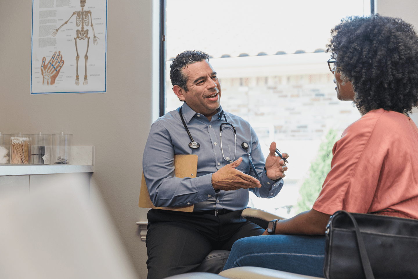 The mid adult female patient and the cheerful mature adult male doctor discuss various treatment options.