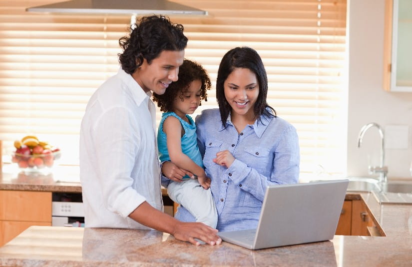 Primary Care Family using laptop in the kitchen together 
