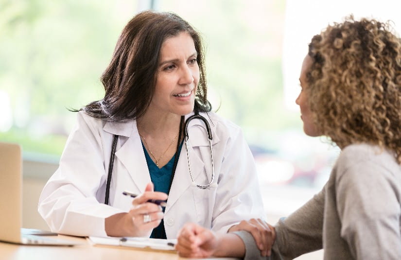 Primary Care Caring doctor encourages young adult patient