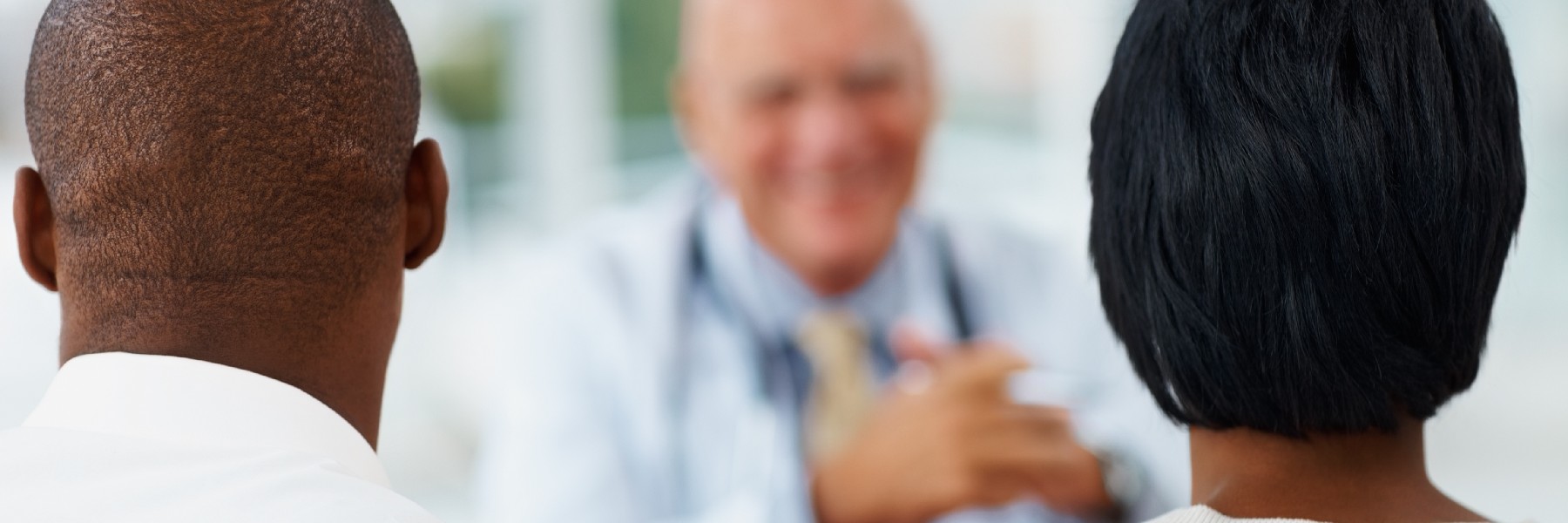African American couple sitting in front of a doctor 