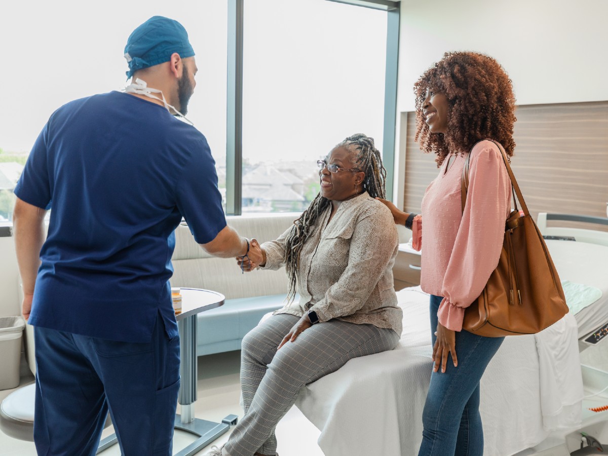 Doctor shaking hands w/ patient and family