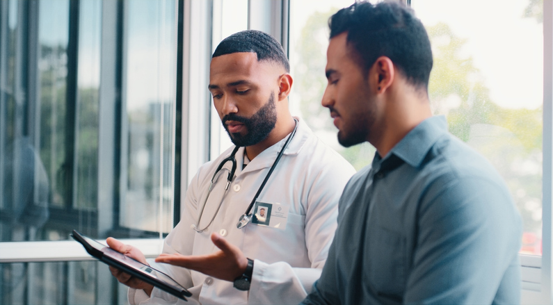 Male doctors talking to male patient