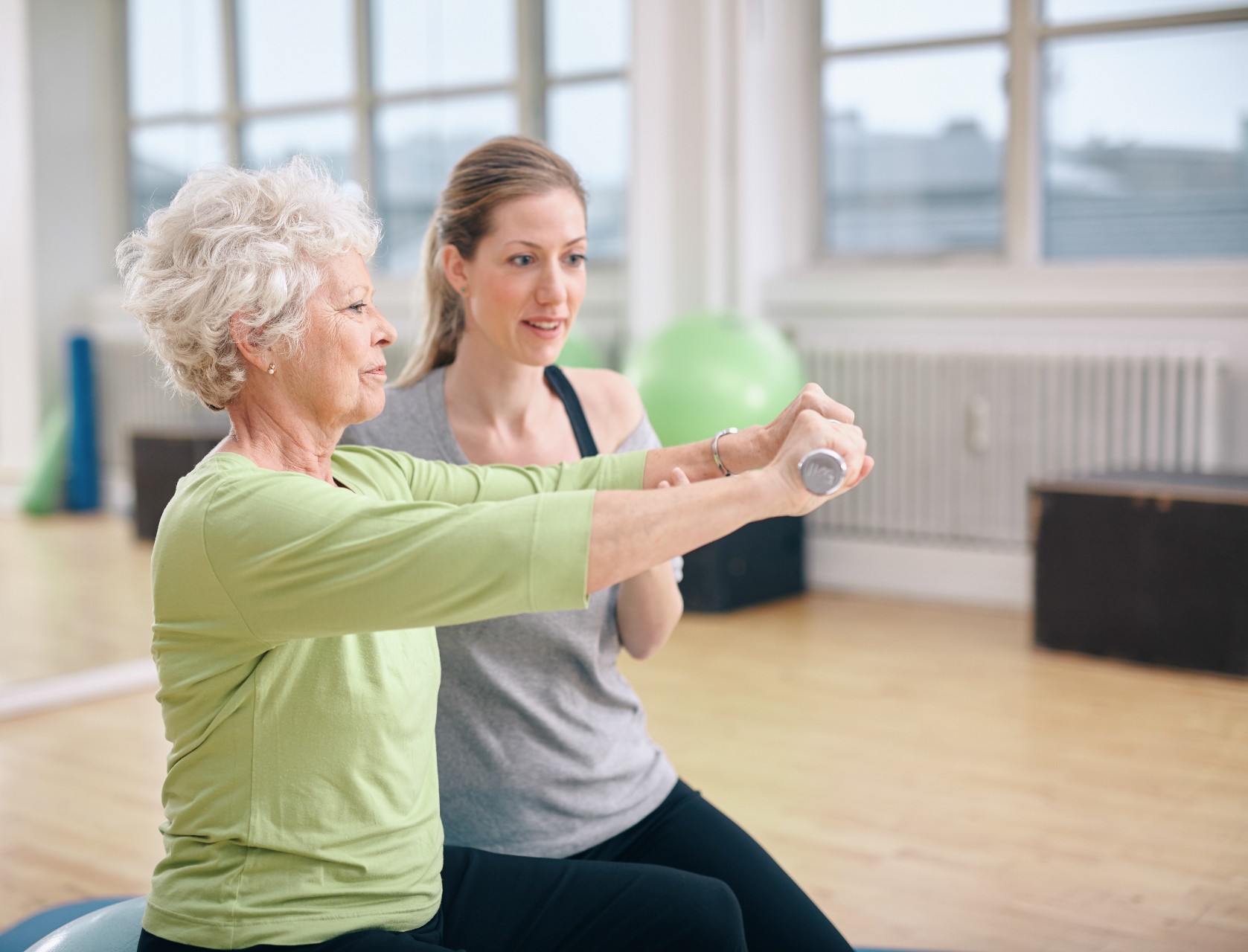 Senior woman training in the gym with a personal trainer