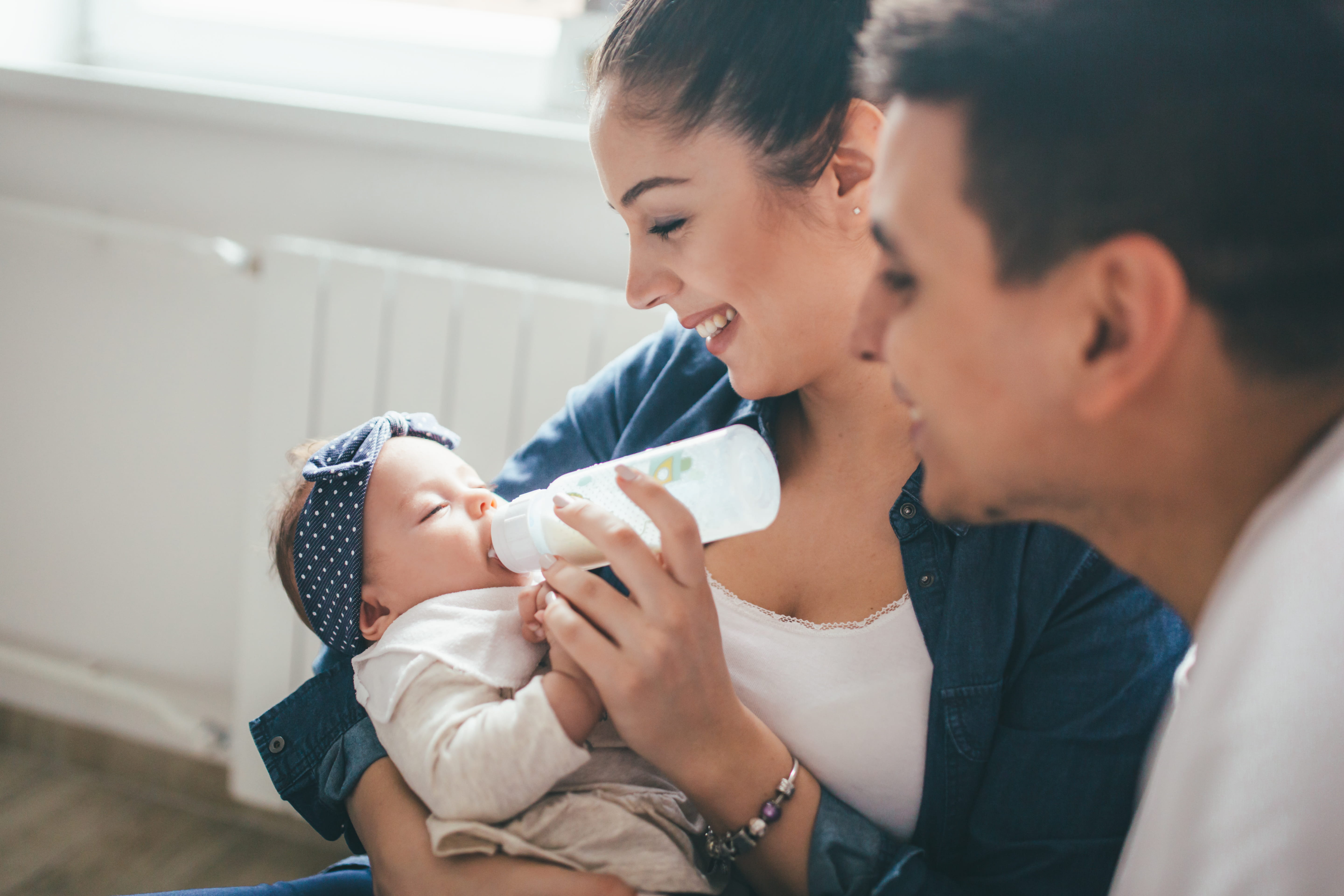 couple bottle feeding their baby