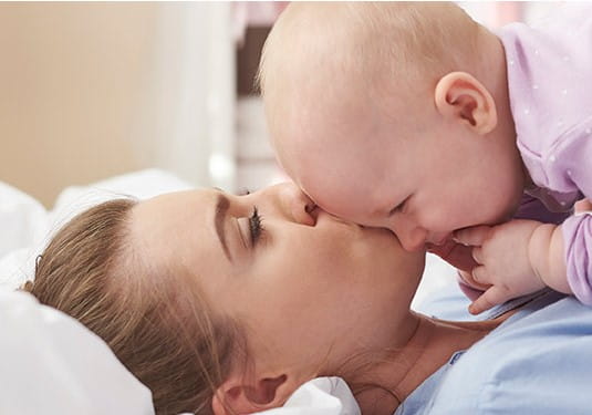 Mother kissing her baby