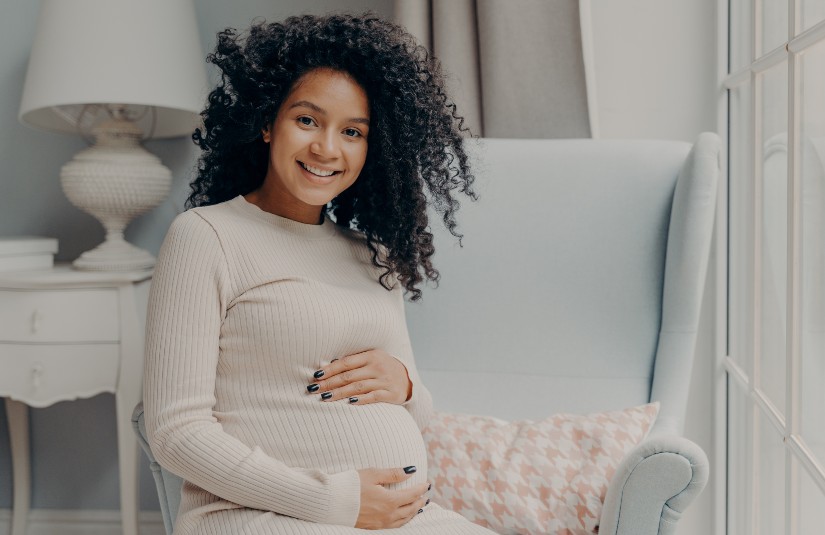 Beautiful pregnant african woman enjoying pregnancy, spending time at home 