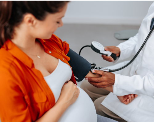  Doctor taking pregnant woman's blood pressure. 