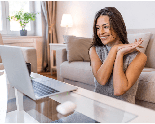  A young woman is using a laptop comfortably in the living room at home.