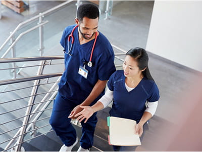 Two healthcare workers walking up stairs