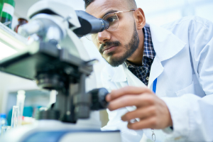 lab tech looking at a microscope