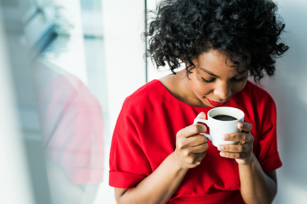 Black woman holding cup of coffee