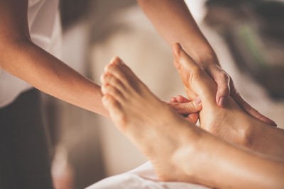 Reflexologist applying pressure to foot