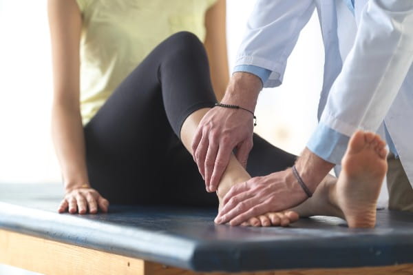 A woman is sitting on an examination table in a doctor's office.