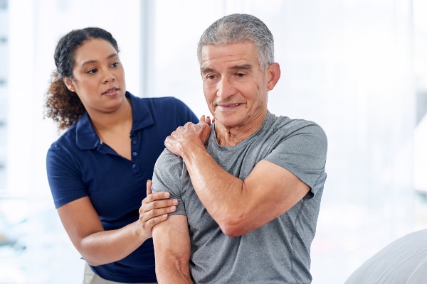 Shot of a senior man experiencing shoulder pain while exercising with his physiotherapist at a hospital
