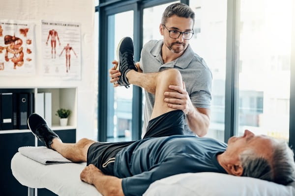 Shot of a friendly physiotherapist treating his mature patient in a rehabilitation center