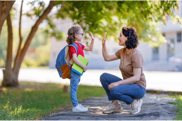 mother and daughter high fiving on the way to school