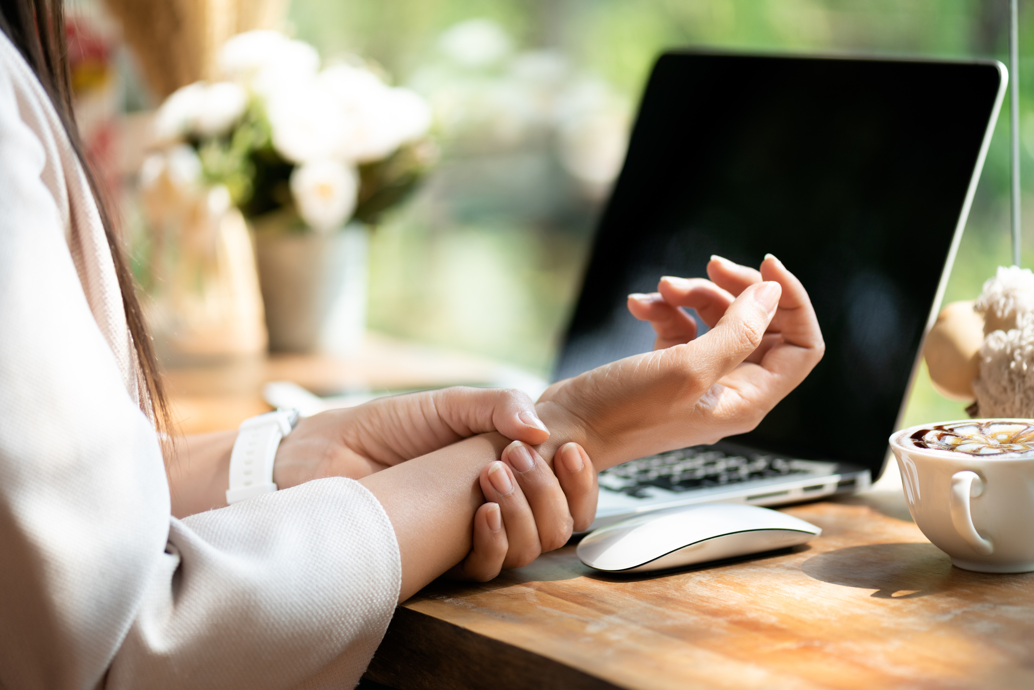 Closeup woman holding her wrist pain from using computer.