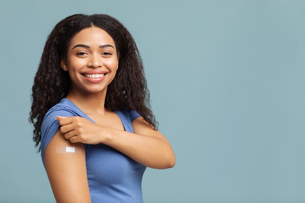 African American Woman in a blue shirt holding up her sleeve