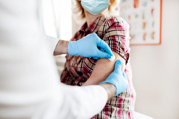 A doctor swabs a woman's arm