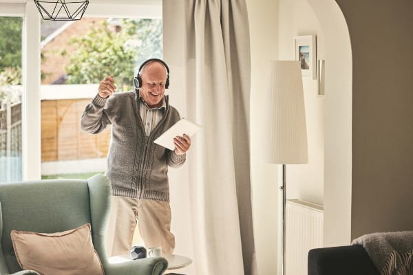 Senior man having fun listening to music on digital tablet