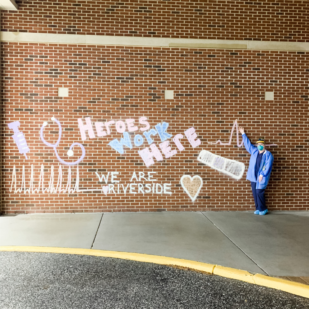 Christen Evans in front of Heroes Work Here chalk mural