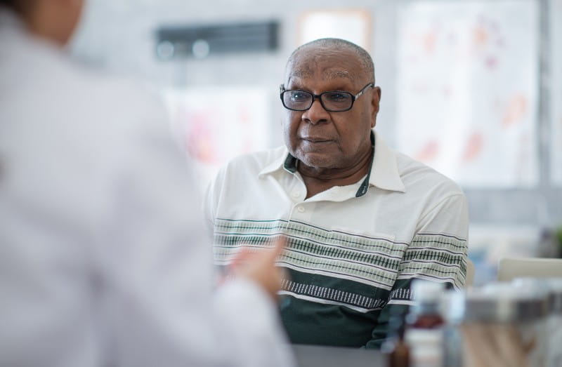 An African American man talks to his doctor in the medical office