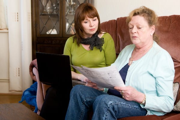 A mature daughter helping mother understand her bills