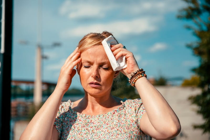 young woman holding an ice pack on her head