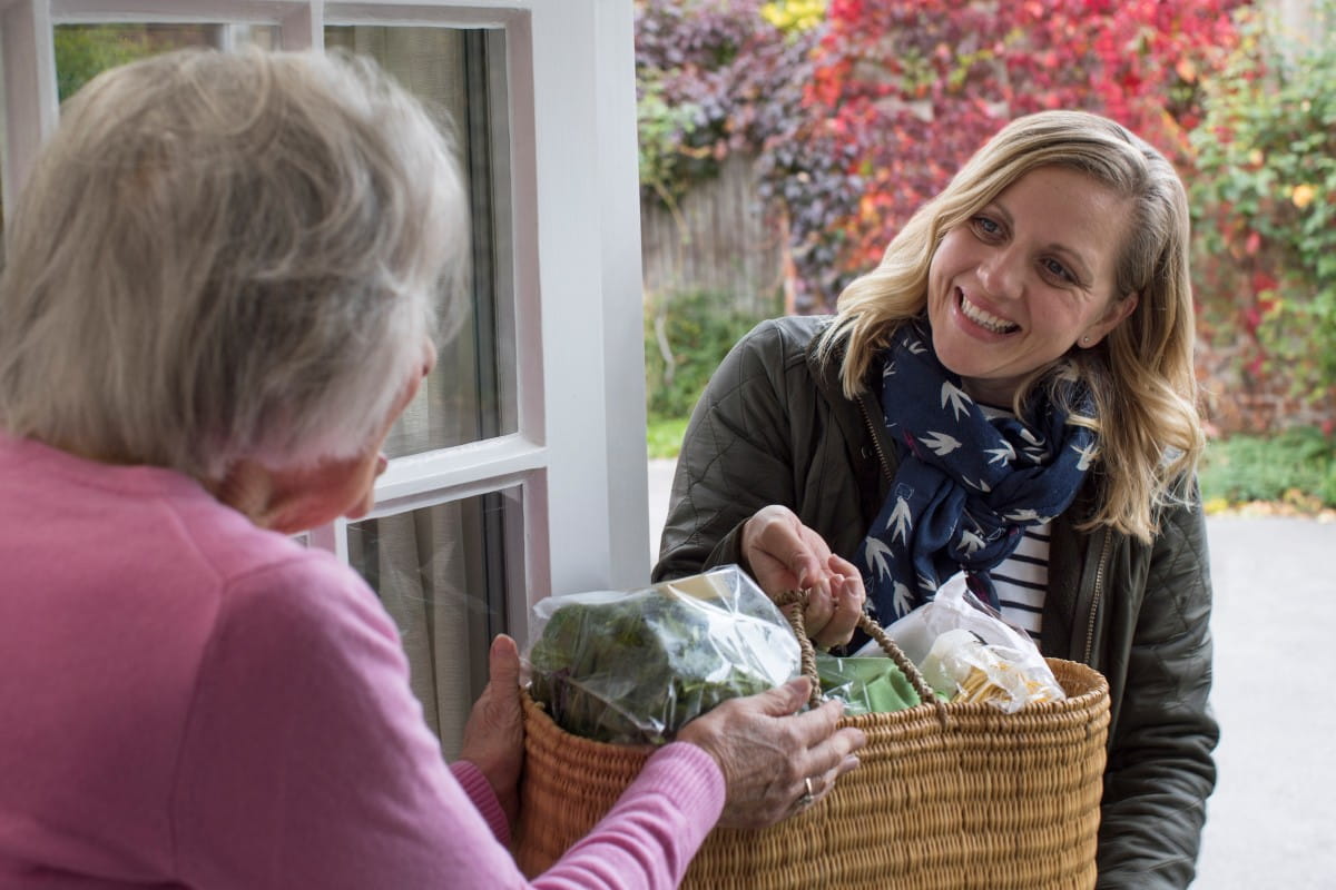 Hospice Bereavement Support Services Female Neighbor Helping Senior Woman With Shopping
