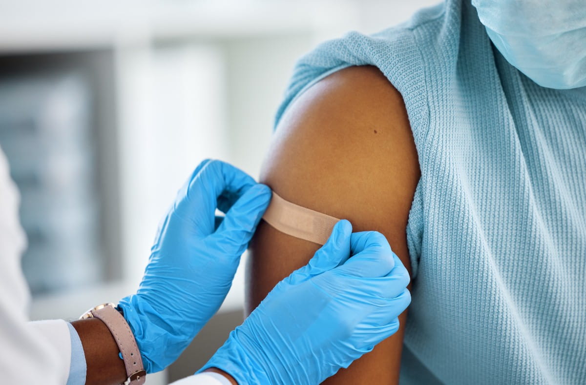  doctor applying a bandaid to patients arm