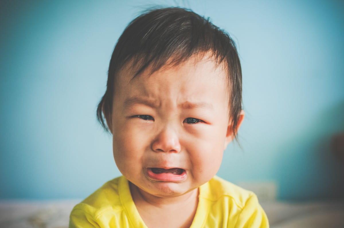 An Asian baby girl crying at home